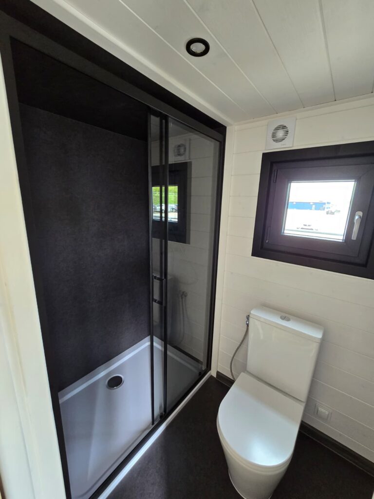 Eine große Dusche und eine Toilette im Badezimmer des Mobilen Hauses „Mia“, Version B