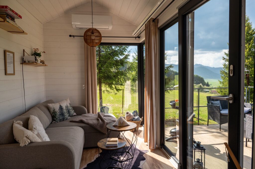 Ein gemütliches, von Tageslicht durchflutetes Wohnzimmer in einem Tiny House mit Erkerfenster