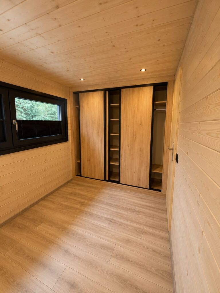 Schlafzimmer mit Naturholzverkleidung im Modulhaus „Modular 2“